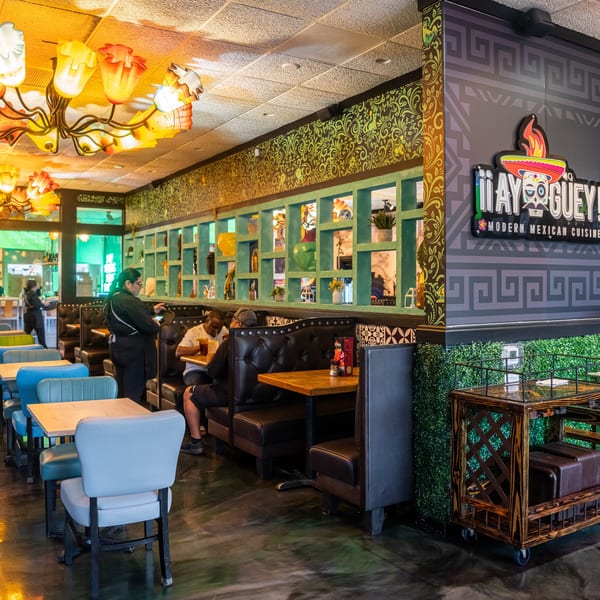 Vibrant interior of a Mexican restaurant with colorful decor, patrons, and staff.
